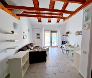 a living room with white walls and wooden ceilings at Sea - View in Himare