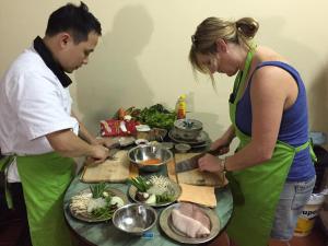 a man and a woman preparing food on a table at VIETNAM APPLE HOMESTAY in Hanoi