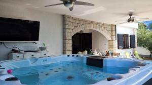a large blue tub in a living room with a tv at Villa Pagar - with hydromassage pool, pets friendly in Povljana