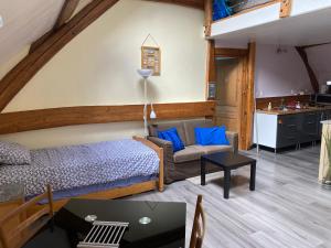a bedroom with a bed and a couch and a table at Hôte à Chaudon in Chaudon