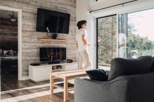 a woman standing in a living room with a fireplace at Chalet le Geai bleu in Chertsey
