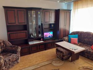 a living room with a tv and a couch and a table at Retro apartment in Malko Tŭrnovo