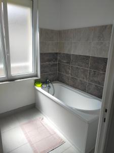 a white bath tub in a bathroom with a window at Bel Appartement 3 étoiles 7 pers 3 pièces 60m2 idéalement placé in Cabourg