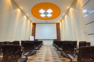 Sala de conferencias con sillas y pantalla de proyección en Grand Voyage Hotel en Almaty