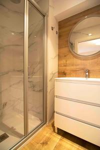 a bathroom with a shower and a sink and a mirror at Apartamentos Leonor in Málaga