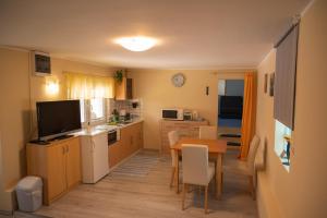 Mursko Središće的住宿－Apartmani Mura，一间带桌子的小厨房和一间餐厅