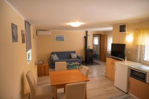 eine Küche und ein Wohnzimmer mit einem Tisch und einem Sofa in der Unterkunft Apartmani Mura in Mursko Središće
