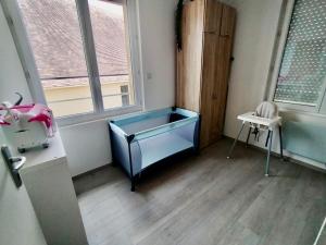 um quarto com uma cama azul num quarto com duas janelas em Bel Appartement 3 étoiles 6 pers 3 pièces 60m2 idéalement placé em Cabourg