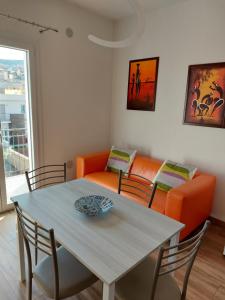 een woonkamer met een tafel en een oranje bank bij Alice apartment in Salemi