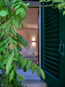 a light in a window with a green shutter at Il Ciclope - La camera sotto il faro in Termoli +5 photos
