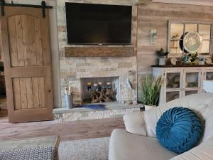 sala de estar con chimenea y TV en Lake Breeze Escape - Your Oasis Awaits 