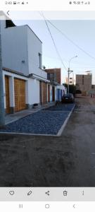 uma rua com um edifício branco e um parque de estacionamento em Departamentos Cerro Azul P1 em Cerro Azul