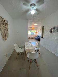 une salle à manger avec une table en verre et des chaises blanches dans l'établissement Hermoso condominio con alberca y club de playa!!, à Manzanillo