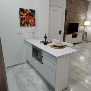 a kitchen with a white island in a room at La Peluquería!! in Ronda