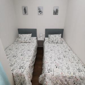 two beds in a small room with white walls at La Peluquería!! in Ronda