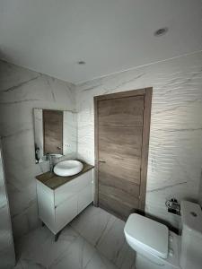 a white bathroom with a sink and a toilet at De la Cuenca Mieres II in Mieres