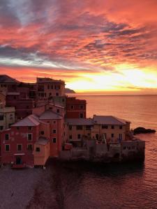 MOONLIGHT IN BOCCADASSE (cod.Citra:010025-LT-2349) في جينوا: مجموعة مباني على الماء مع غروب الشمس