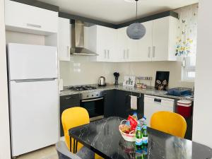 uma cozinha com uma mesa com cadeiras e um frigorífico branco em Aether Flats No7,Old Town, Beach, Central, Netflix em Antália