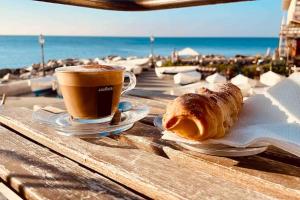 uma mesa com uma chávena de café e um croissant em MOONLIGHT IN BOCCADASSE (cod.Citra:010025-LT-2349) em Gênova