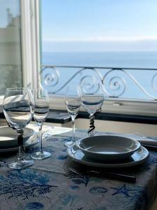 a table with three wine glasses and a plate on it at MOONLIGHT IN BOCCADASSE (cod.Citra:010025-LT-2349) in Genova