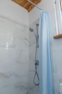 łazienka z prysznicem z niebieską zasłoną prysznicową w obiekcie Domki Snopki w Piszu