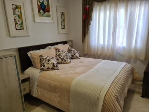 a bedroom with a bed with pillows on it at Pousada Lugama in Bento Gonçalves