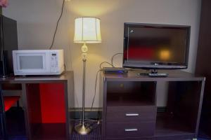 a room with a microwave and a television on a table at Travel inn in North Kingstown