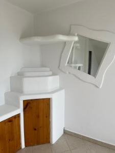 een witte kamer met een spiegel aan de muur bij APARTMENTS RATZERSDORFER SEEN in 3100 SANKT PÖLTEN in Sankt Pölten
