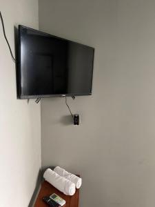 einen Flachbild-TV, der an einer Wand hängt in der Unterkunft Esquina 8 Suítes Confort & Hostel in Florianópolis
