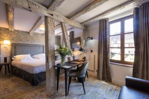 a hotel room with a bed and a desk at Logis Hôtel-Restaurant du Mouton in Ribeauvillé