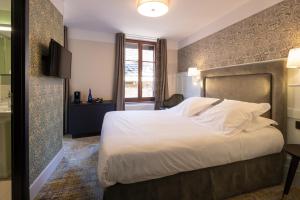 ein Schlafzimmer mit einem großen Bett und einem Fenster in der Unterkunft Hôtel-Restaurant du Mouton in Ribeauvillé