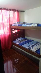 two bunk beds in a room with red curtains at Bosques de cuba in Pereira