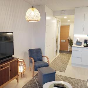 a living room with a tv and a chair at Lovely new city apartment all amenities in Seinäjoki