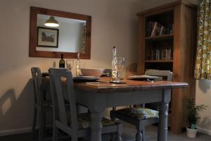 a dining room table with chairs and a mirror at West View Cottage in Worcester