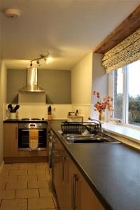 a kitchen with a sink and a stove at West View Cottage in Worcester