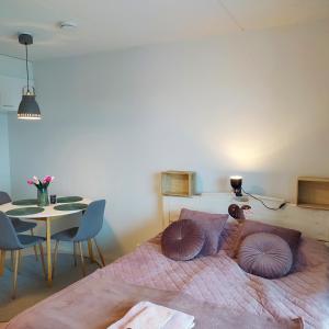 a bedroom with a bed with pillows and a table at Lovely new city apartment all amenities in Seinäjoki