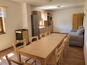 a kitchen and dining room with a wooden table and chairs at Chaty u Tesaru in Bítov