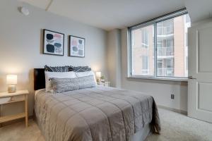 a bedroom with a bed and a large window at Wonderful 2BR Condo At Crystal City With Rooftop in Arlington