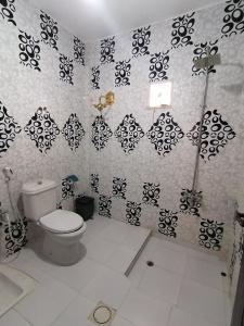 a bathroom with a toilet and black and white wallpaper at Petra paradise home in Wadi Musa