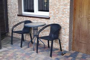 two chairs and a table next to a brick wall at Apartamenty rodzinne U Zośki in Łukęcin