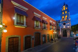 a street with a building and a clock tower at Hotel Boutique Casona de la China Poblana - Adults Only in Puebla