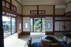 a person jumping out of a door in a room at 風早邸海音 kazahayatei mion in Hōjō