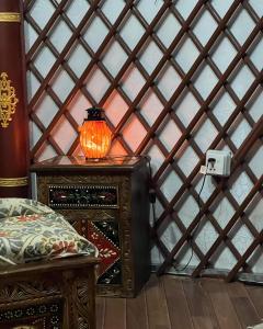 a room with a bed and a lamp on a wall at The Glamping Spot Kalam in Kalām