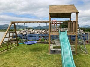 a playground with a slide and a swing set at The Loft - Shemara 