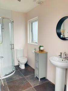 a bathroom with a toilet and a sink and a shower at The Loft - Shemara 