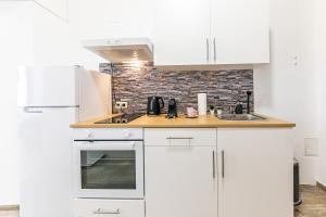 a kitchen with white cabinets and a sink at Premium City Apartment in Center of Vienna in Vienna