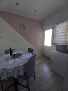a dining room with a table and chairs and a window at Apartman Maja in Kaštela