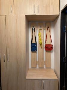 une armoire avec trois sacs suspendus et un porte-monnaie dans l'établissement Royal Studio National Arena - Free Parking, à Bucarest