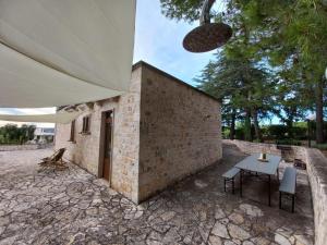 un patio con mesa y un edificio en Trulli Pinnacoli, en Locorotondo