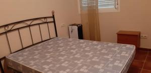 a bedroom with a bed with a gray and white bedspread at Pozo de esparto in El Pozo del Esparto